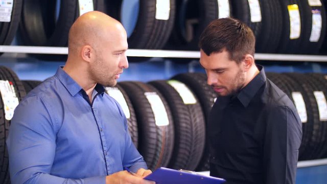customer and salesman at car service or auto store