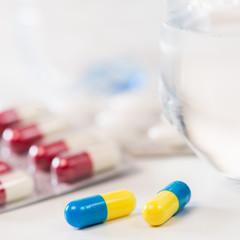 Colorful tablets with capsules and pills on white background