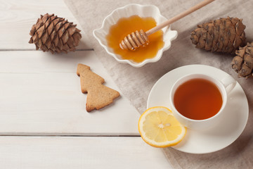 Black tea with lemon, cookie and honey. Charming winter background, with space for text