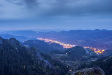 Bulgarian city Smolyan before dawn in the rain. The shining lights of the city are like a river in the heart of Rodopi mountain.