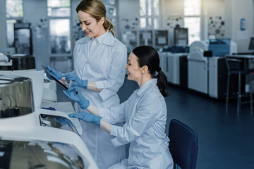 Relationships with colleagues. Happy positive nice women talking to each other and discussing work while working in the lab