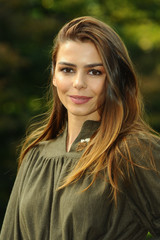 Obraz premium Outdoors portrait of emotional young beautiful young woman on autumn foliage background.