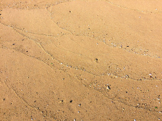 Tracks left by waves on the sand, texture