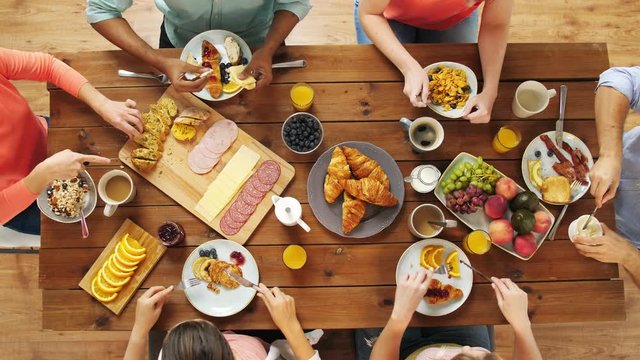 group of people eating at table with food