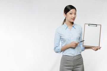 Young Asian business woman point to blank clipboard isolated on white background, with  copy space for product or text, isolated on white background