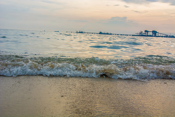 Fototapeta premium Artistic photo. Close-up on a wave withdrawing on the sand of a beach in the sunset