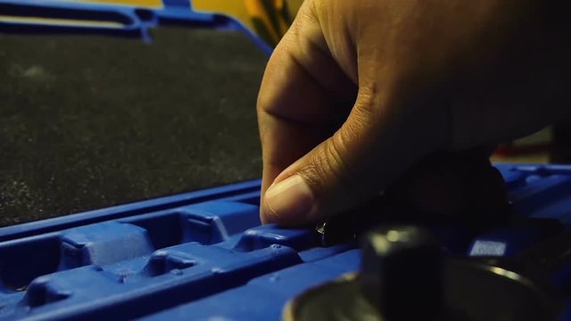 Male hand putting back socket wrench pieces in to plastic carrying case. Cleaning up after service. Filmed in slow motion hd.