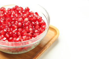 pomegranate seeds in glass bowl isolated on white background