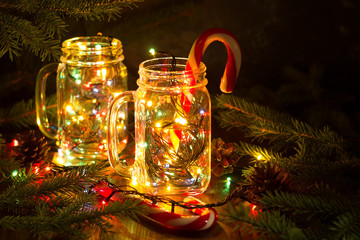 Christmas fairy garland lights in a glass jar shine in the night darkness. - 179295878