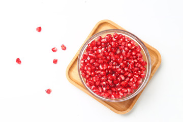 pomegranate seeds in glass bowl isolated on white background