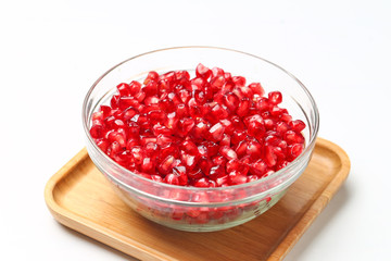pomegranate seeds in glass bowl isolated on white background