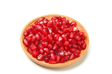 pomegranate seeds in wooden plate isolated on white background