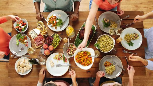 group of people eating at table with food
