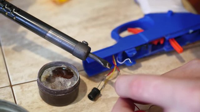 male hand closeup solder 2 wires . Repair of electrical appliances, soldering tin