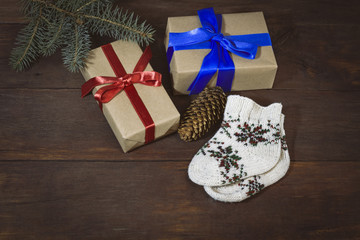 Packed gifts with red and blue ribbons, socks ornament, spruce branch, fir cone