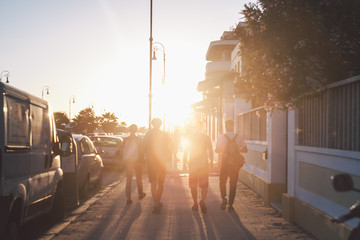 friends walking through the street in sunset