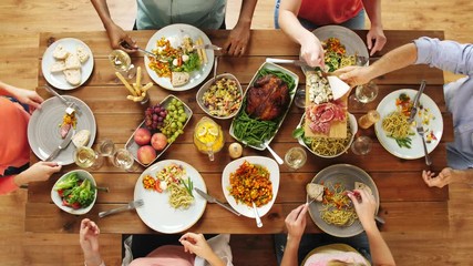 group of people eating at table with food - Powered by Adobe