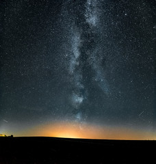 natural night sky with milky way visible and city lights coming up. 