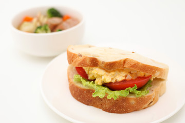 お皿にのせた エッグレタストマトサンド パン サンドウィッチ 白背景