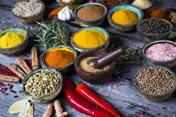 Herbs and spices on a wooden bowl background 