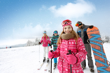 Smiling girl with family on ski terrain