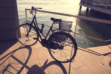 Fototapeta na wymiar bicycle with basket on the coast on the sunset