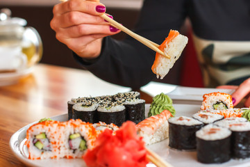 sushi and rolls, Japanese cuisine, a girl eating sushi