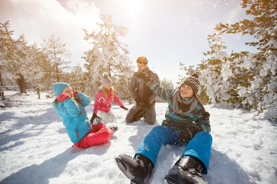 Family having fun on snow in mountain at winter