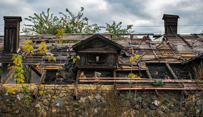 Fototapeta na wymiar An big old abandoned ruined wooden building