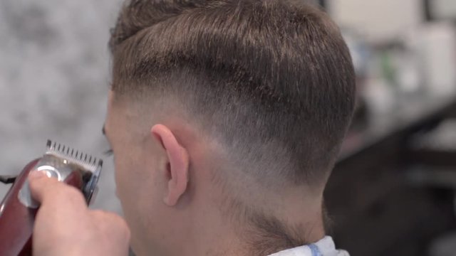 Man getting a haircut by a hairdresser.