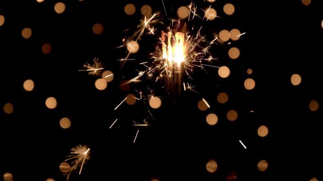 Sparklers burning in front of ambient lights. Gun powder sparks shot against bokeh lights background. 4k