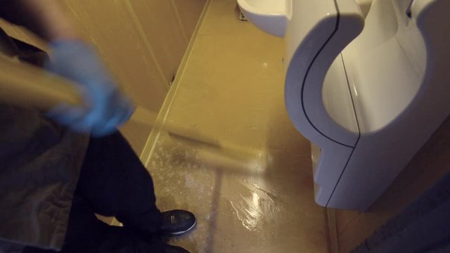 clean swiping a public restroom floor