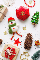 Christmas background with decorations. New Year symbol - decorative fir tree. Gifts in craft paper, pine cones and confetti. Flay lay, top view.