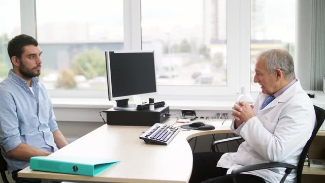 senior doctor talking to male patient at hospital