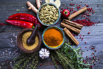 Herbs and spices on a wooden bowl background 