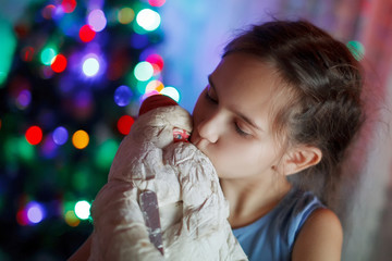 happy girl child in expectation of a miracle hugging a toy father Christmas