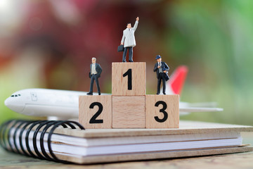Miniature people: Businessman with numbers in gold, silver, bronze and plane.  Business team competition concept.