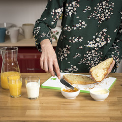 Woman spreading honey on half of croissant