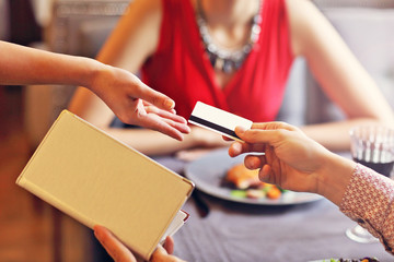 People paying in restaurant by credit card reader