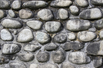 Detail of a wall made of river stones, stone background, wall, pavement, grey and brown dark colors