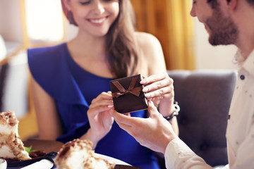Romantic couple dating in restaurant and giving present