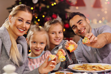 Obraz na płótnie Canvas Joyful family preparing Christmas biscuits