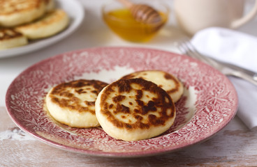 Cottage cheese pancakes, homemade syrniki with honey and sour cream.