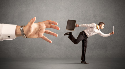 Businessman running from hand