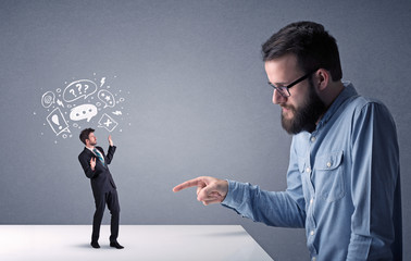 Young businessman fighting with miniature businessman