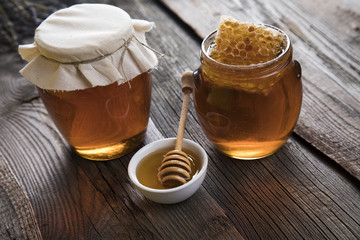 Honey and wooden stick are on a table