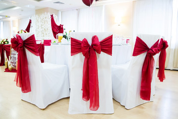Wedding chairs for guests decorated with red ribbons