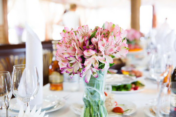 Served table in the restaurant with flower composition