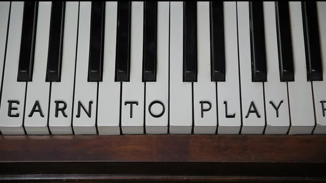 LEARN TO PLAY PIANO written on white keys