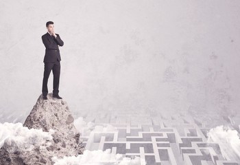 Businessman on cliff above labyrinth